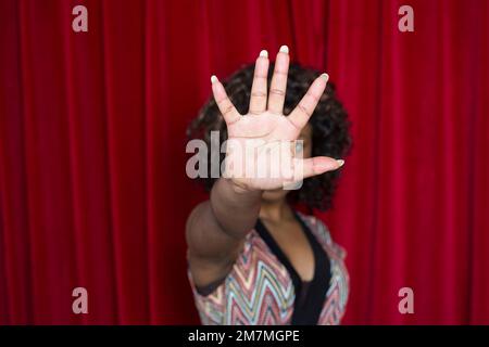 Young woman holds her hand defensively in front of her face Stock Photo