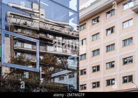 apartment buildings reflected in a building with a mirrored facade Stock Photo