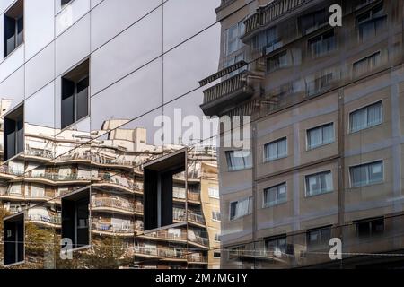 apartment buildings reflected in a building with a mirrored facade Stock Photo