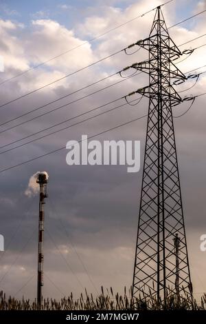 high voltage pylons silhouette cloudy sky background Stock Photo - Alamy
