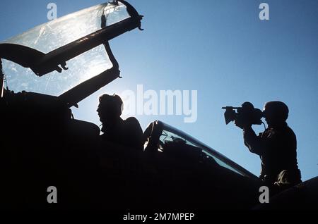 SSGT William Wood, an Air Force Audiovisual Service motion picture cameraman, films early morning maintenance being performed on an F-4 Phantom II aircraft. The F-4 from the 9th Tactical Fighter Squadron, has just completed a trans-Atlantic flight from Holloman Air Force Base, New Mexico to participate in exercise Crested Cap '77. Subject Operation/Series: CRESTED CAP '77 Base: Ramstein Air Base State: Rheinland-Pfalz Country: Deutschland / Germany (DEU) Stock Photo