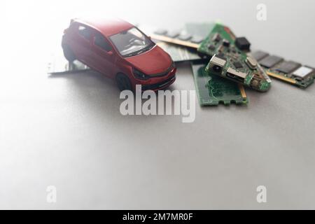 Toy cars on an electronic board with integrated circuits. The shortage of microchips and semiconductors creates a shortage of new cars. semiconductor Stock Photo
