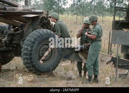 A US Army artillery crew receives firing coordinates for an M114 155 mm howitzer during a training exercise. Country: Unknown Stock Photo