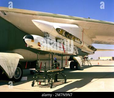 A left front view of an AGM-86 air launched cruise missile (ALCM) mounted on a B-52 Stratofortress aircraft as an airman prepares to unload the missile. Country: Unknown Stock Photo