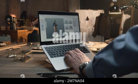 Fashion designer creates clothes and develops future wear collection in 3D modeling program. Male tailor works in luxury designer workshop or tailoring studio on laptop. Fashion concept. Stock Photo