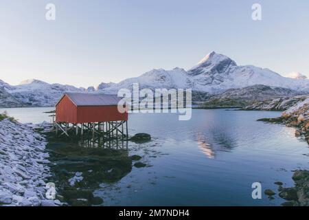 Traditional fishing hut on stilts, Norway, typical fjord landscape with mountains and stilt house Stock Photo