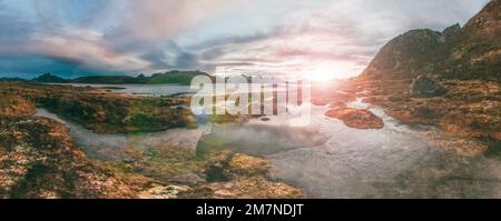 Typical fjord landscape in autumn at sunset in Vesteralen, Norway, panorama of Nordic coastal landscape with rocks, sea, marshland, mountains and waters Stock Photo