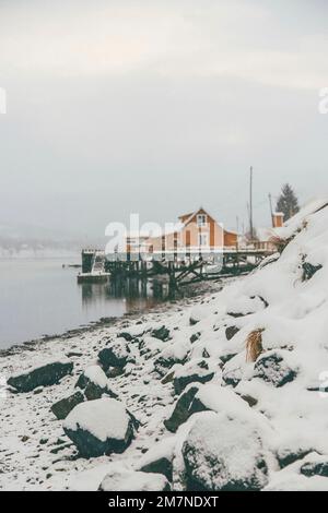 yellow rorbu houses on the coast, fishing village in Vesteralen, Norway, snowfall, winter Stock Photo