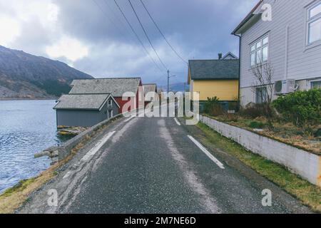 Lonely fishing hut by the road on the fjord in Norway, typical fjord landscape with small islands, seclusion from the outside world, house by the lake Stock Photo