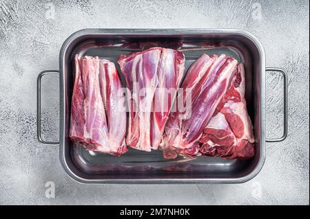 Fresh Raw lamb shanks meat in a steel tray. White background. Top view. Stock Photo