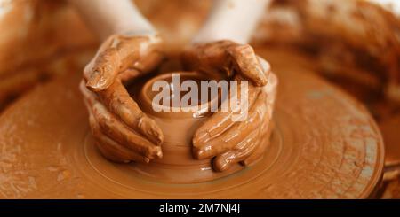 Cropped Image of Unrecognizable Female Ceramics Maker working with Pottery Wheel in Cozy Workshop Makes a Future Vase or Mug,Creative People Handcraft Stock Photo
