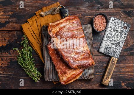 Meat restaurant kitchen. Smoked BBQ Pork Ribs on wooden cutting board. Wooden background. Top view Stock Photo