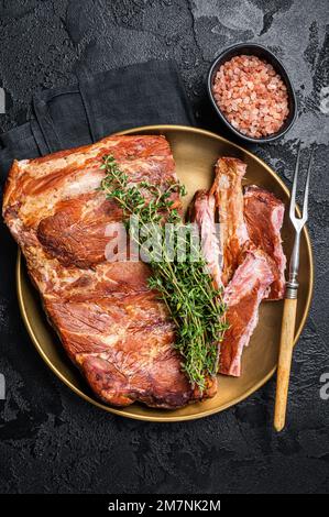 Grilled in BBQ Pork spare Ribs on steel plate with thyme. Black background. Top view Stock Photo