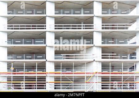 Building featuring numerous windows with construction scaffolding in front of it. Stock Photo