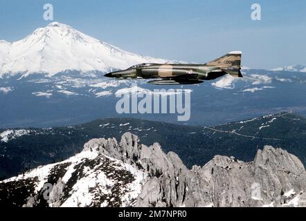 AN air-to-air left side view of an RF-4C Phantom II aircraft. The aircraft is from the 152nd Tactical Reconnaissance Group, Nevada Air National Guard. A snow-capped mountain is in the background. Base: Sierra Mountains State: Nevada (NV) Country: United States Of America (USA) Stock Photo