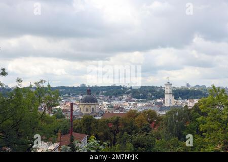 LVIV, UKRAINE - SEPTEMBER 11, 2022 Panorama view of the historical old city in Lviv, Ukraine. Many old buildings with metal roofs and cathedral domes in beginning of autumn day Stock Photo