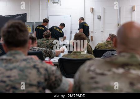 U.S. Marines from 2d Radio Battalion, II Marine Expeditionary Force Information Group, 30 Commando Royal Marines, and soldiers with 7th Signal Regiment, Australian Army, discuss an upcoming night air-insert during Radio Reconnaissance Operators Course (RROC) May 11, Camp Lejeune, North Carolina. RROC is aiming to establish a formal course that combines the skill sets taught in various existing signals intelligence, electronic warfare and reconnaissance courses in order to produce radio reconnaissance Marines. This is the third iteration of the course and the first to be held at Camp Lejeune, f Stock Photo