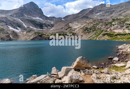 Blue Lake - A panoramic view of pristine Blue Lake at base of summit of Mount Toll on a sunny Summer afternoon. Indian Peaks Wilderness, Colorado, USA. Stock Photo