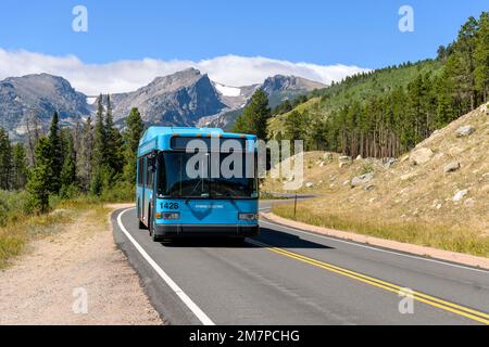 Shuttle on Bear Lake Road - A hybrid electric shuttle bus running on scenic Bear Lake Road on a sunny Summer morning in Rocky Mountain National Park. Stock Photo