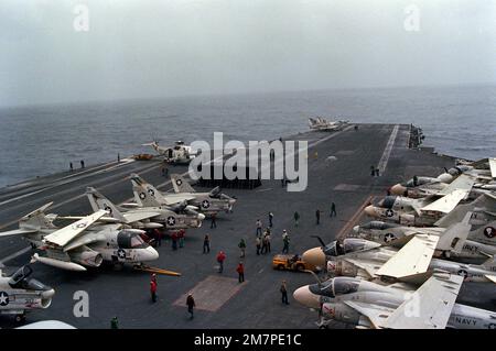 An elevated view of the forward section of the flight deck of the nuclear-powered aircraft carrier USS DWIGHT D. EISENHOWER (CVN-69) during aircraft launch and recovery operations. Parked behind the raised blast deflector panels are three A-7E Corsair II aircraft and an S-3 Viking aircraft. On the starboard side of the flight deck are four A-6E Intruder aircraft, an S-3 and an A-7E. Base: USS Dwight D Eisenhower (CVN 69) Stock Photo