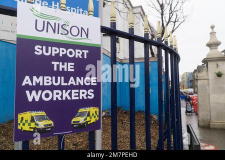 London, UK, 10 January 2023: At Kings College Hospital, London, a Unison placard asks for people to support striking ambulance workers. Inside the hospital grounds, transport ambulances are parked in a row. Anna Watson/Alamy Live News Stock Photo