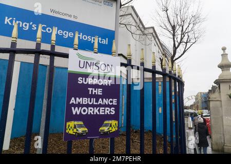 London, UK, 10 January 2023: At Kings College Hospital, London, a Unison placard asks for people to support striking ambulance workers. Inside the hospital grounds, transport ambulances are parked in a row. Anna Watson/Alamy Live News Stock Photo