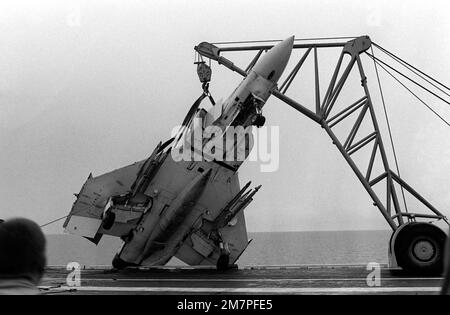 A crane is used to lift an F-4 Phantom II aircraft away from the port ...