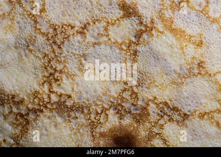 Pancake surface texture and pattern. Close-up of thin hot pancakes in a plate. Traditional rustic food. Graphic resource. Table top view. Stock Photo