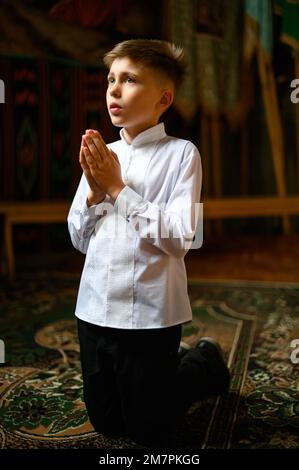 The boy is kneeling in prayer to God Stock Photo - Alamy