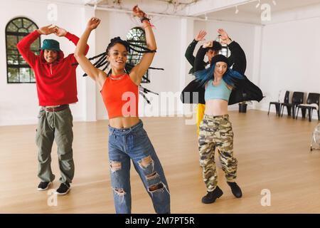 Image of group of group of diverse female and male hip hop dancers practicing in dance studio Stock Photo