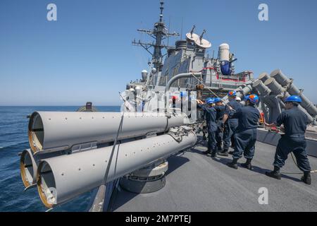 PHILIPPINE SEA (May 11, 2022) Sailors load a torpedo on the fantail of Arleigh Burke-class guided missile destroyer USS Benfold (DDG 65). Benfold is assigned to Commander, Task Force (CTF) 71/Destroyer Squadron (DESRON) 15, the Navy’s largest forward-deployed DESRON and the U.S. 7th Fleet’s principal surface force. Stock Photo