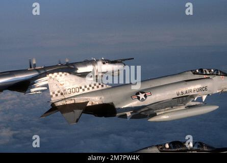 AN air-to-air right side view of two F-4 Phantom II aircraft observing a Soviet TU-95 Bear aircraft, rear, over international waters. Country: North Atlantic Ocean Stock Photo