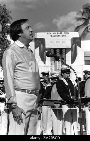 Jim Nabors sings the national anthem at the beginning of a ceremony marking the transfer of the U.S. flag flown over Hickam during the 1941 Japanese attack from the Air Force Academy Museum back to the base. Base: Hickam Air Force Base State: Hawaii (HI) Country: United States Of America (USA) Stock Photo