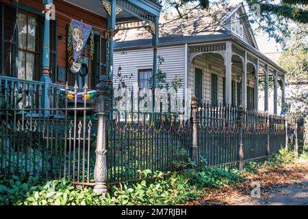 NEW ORLEANS, LA, USA - DECEMBER 9, 2022: Early 20th century homes on S. Carrollton Avenue, one colorful home with Mardi Gras decorations Stock Photo