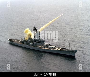 Aerial starboard bow view of the battleship USS NEW JERSEY (BB 62) launching an RGM-84 Harpoon missile on the Pacific Missile Test Center Range. Country: Pacific Ocean (POC) Stock Photo