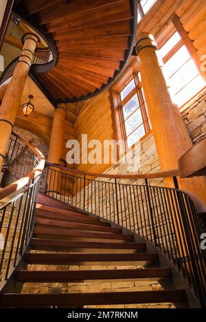 Picture of Curved and spiraling wood and wrought iron staircase leading to main ...
