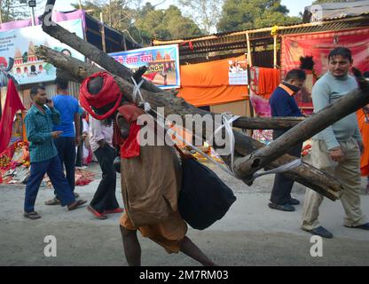 Kolkata, West Bengal, India. 11th Jan, 2023. A physically challenged pilgrim carrying wood on his shoulder walking towards his tent on Gangasgara transits camp in Kolkata. (Credit Image: © Sudipta Das/Pacific Press via ZUMA Press Wire) EDITORIAL USAGE ONLY! Not for Commercial USAGE! Stock Photo