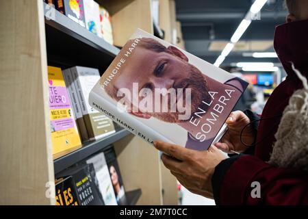 Barcelona, Spain. 10th Jan, 2023. A woman is seen holding the spanish edition of Prince Harry's memoir book, entitled 'En la Sombra', original title 'Spare', inside an 'Abacus' bookstore in the city center. Credit: SOPA Images Limited/Alamy Live News Stock Photo