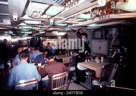 Crewmen eat in the dining hall during precommissioning duty aboard the ...