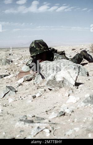A United States Marine behind the cover of a mud wall during a combat ...