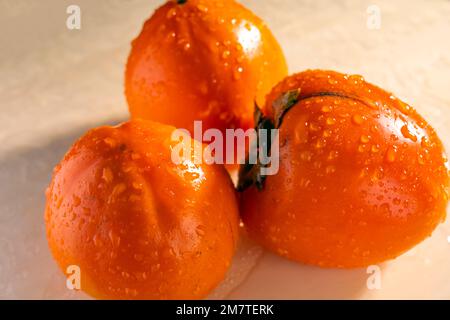 fresh juicy persimmon on the table close-up Stock Photo