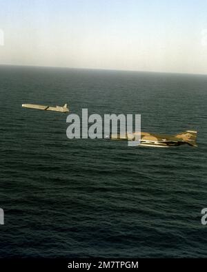 A left side view of an AGM-86 air-launched cruise missile being followed by a photo chase RF-4C Phantom II aircraft near Vandenberg Air Force Base. Country: Pacific Ocean (POC) Stock Photo