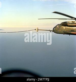 A left side view of an RH-53D Sea Stallion helicopter being refueled by a KC-130F Hercules aircraft from Marine Refueler-Transport Squadron 252 (VMGR-252), not visible. Base: Cape Hatteras State: North Carolina (NC) Country: United States Of America (USA) Stock Photo