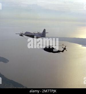 A left side view of a KC-130F Hercules aircraft from Marine Refueler-Transport Squadron 252 (VMGR-252) refueling an RH-53D Sea Stallion helicopter from Helicopter Mine Countermeasures Squadron 12 (HM-12). Base: Cape Hatteras State: North Carolina (NC) Country: United States Of America (USA) Stock Photo