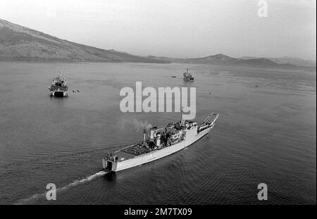 An aerial starboard quarter view of the Newport-class tank landing ship USS FRESNO (LST 1182) underway while supporting a Marine Corps amphibious beach assault exercise. Country: Unknown Stock Photo