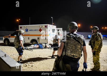 U.S. Air Force field response team members, with the 378th Expeditionary Medical Squadron, and firefighters, with the 378th Expeditionary Civil Engineer Squadron, transport a simulated casualty on a  stretcher at Prince Sultan Air Base, Kingdom of Saudi Arabia, May 13, 2022. The 378th Air Expeditionary Wing held an airborne missile attack exercise that included a simulated mass casualty incident. Stock Photo