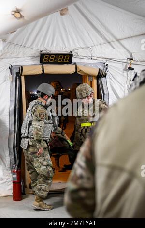 U.S. Air Force field response team members, with the 378th Expeditionary Medical Squadron, and firefighters, with the 378th Expeditionary Civil Engineer Squadron, transport a simulated casualty into a medical tent at Prince Sultan Air Base, Kingdom of Saudi Arabia, May 13, 2022. The 378th Air Expeditionary Wing held an airborne missile attack exercise that included a simulated mass casualty incident. Stock Photo