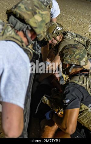 U.S. Air Force field response team members, with the 378th Expeditionary Medical Squadron, and firefighters, with the 378th Expeditionary Civil Engineer Squadron, stabilize and safely load a simulated casualty onto a stretcher on Prince Sultan Air Base, Kingdom of Saudi Arabia, May 13, 2022. The 378th Air Expeditionary Wing held an airborne missile attack exercise that included a simulated mass casualty incident. Stock Photo