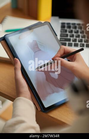 Closeup image of creative woman drawing fashion sketches on digital tablet Stock Photo
