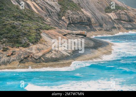 A man is fishing on big rocks, with big waves in Salmon hole, Albany, Western Australia Stock Photo